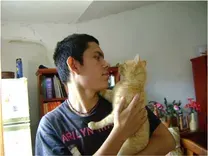 Persona sosteniendo un gato anaranjado en una habitación.