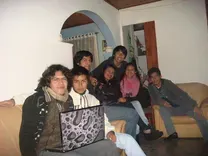 Grupo de siete personas reunidas en una habitación, con una computadora portátil.